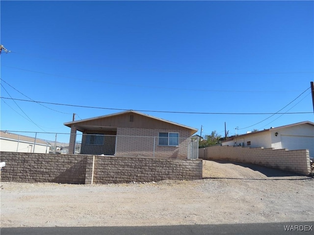 view of property exterior featuring fence and brick siding