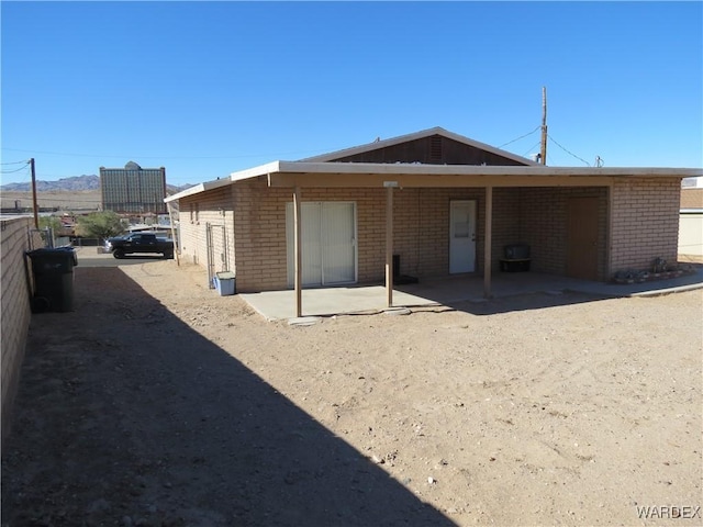 rear view of house with a patio and brick siding