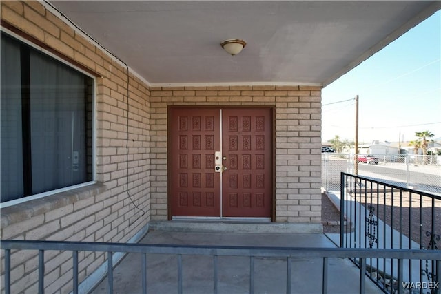 view of exterior entry featuring brick siding