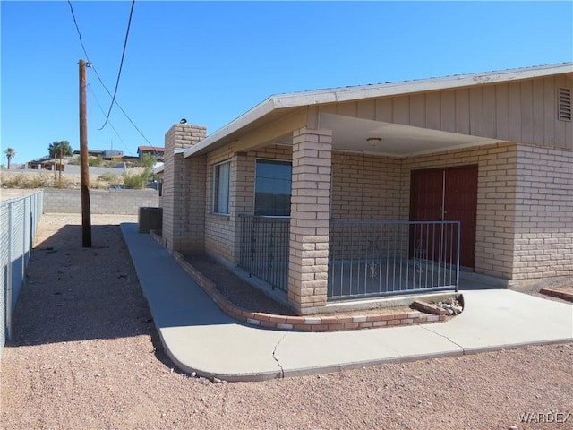 view of home's exterior featuring fence and brick siding