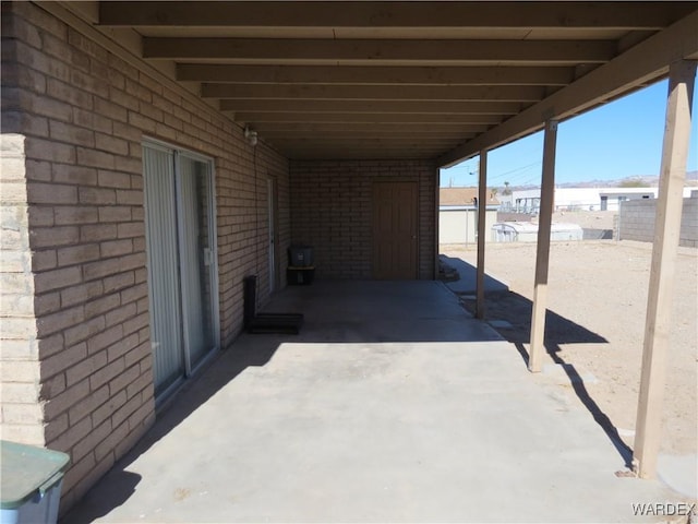 view of patio featuring a carport and fence