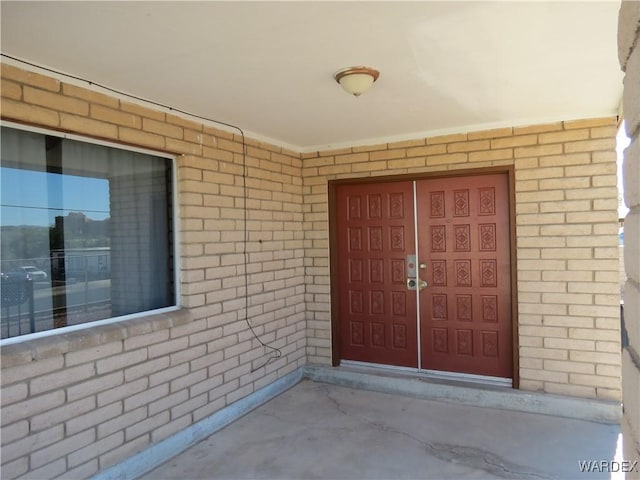 view of exterior entry featuring brick siding