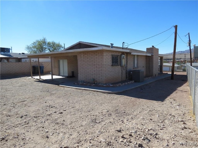 back of house with central AC, brick siding, a patio area, and fence