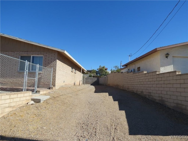 view of side of home featuring brick siding and fence