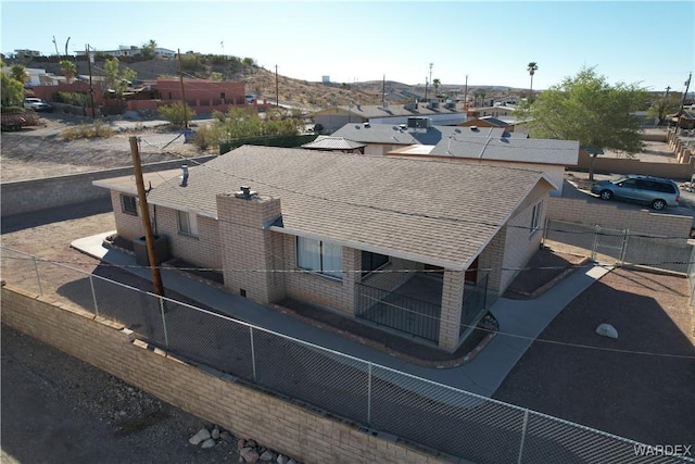 exterior details with a residential view, roof with shingles, and fence