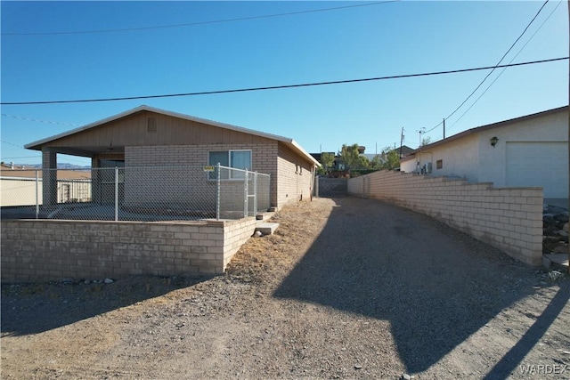 view of side of property featuring brick siding and fence