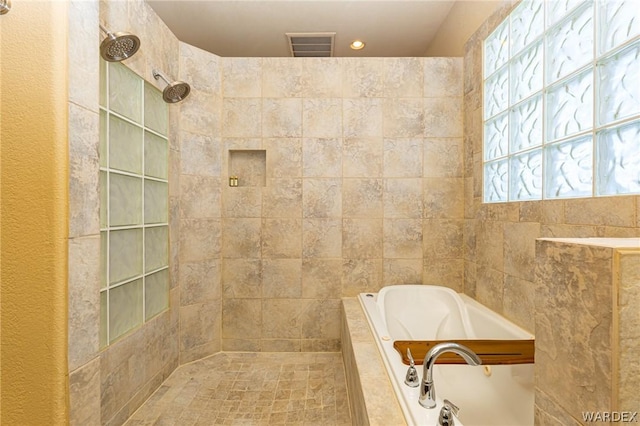 bathroom featuring visible vents, a walk in shower, and a bath