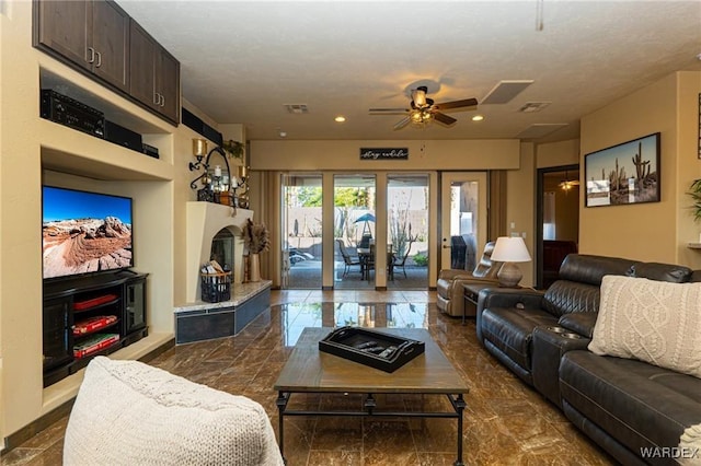 living area with visible vents, a fireplace with raised hearth, ceiling fan, marble finish floor, and recessed lighting