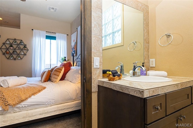 bathroom with vanity, visible vents, and ensuite bathroom