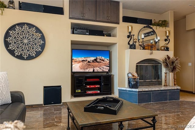 living room with marble finish floor, a fireplace, and baseboards