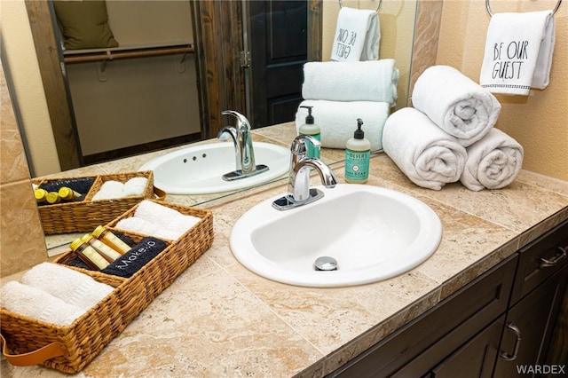 bathroom featuring a walk in closet and vanity