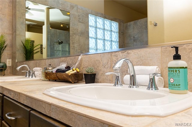 full bathroom with double vanity, tile walls, walk in shower, and a sink