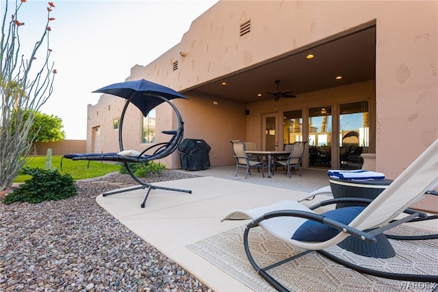 view of patio featuring ceiling fan, outdoor dining space, fence, and visible vents