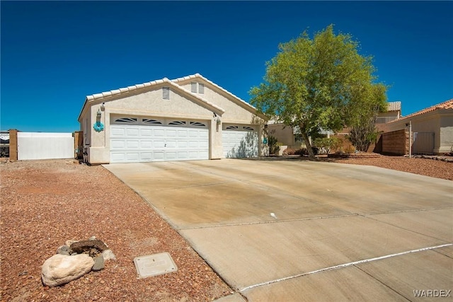 2355 Morningside Dr, Bullhead City, AZ 86442 - ranch-style home featuring driveway, fence, a tiled roof, an attached garage, and stucco siding