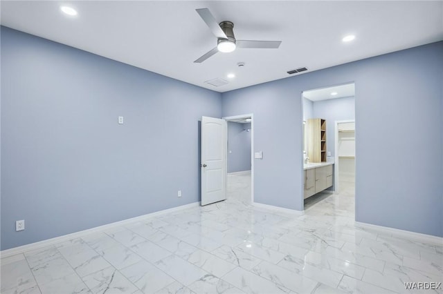 unfurnished bedroom featuring marble finish floor, a spacious closet, visible vents, and baseboards