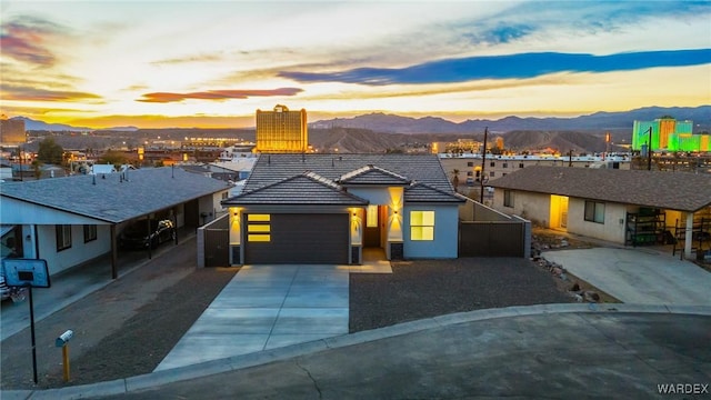 view of front of property with an attached garage, a mountain view, concrete driveway, a tiled roof, and stucco siding