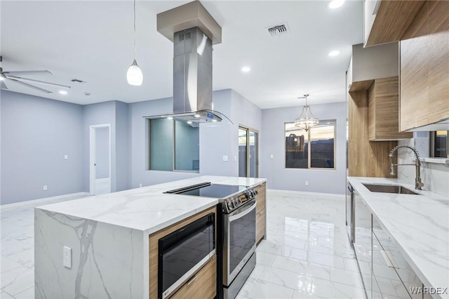 kitchen with hanging light fixtures, island exhaust hood, appliances with stainless steel finishes, and a sink