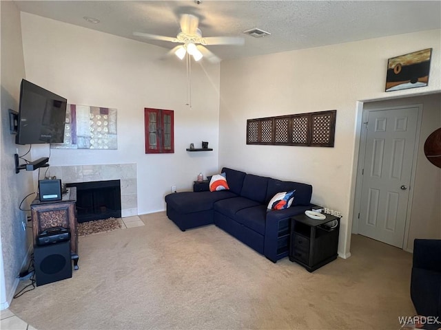 living room with visible vents, a ceiling fan, carpet, and a premium fireplace