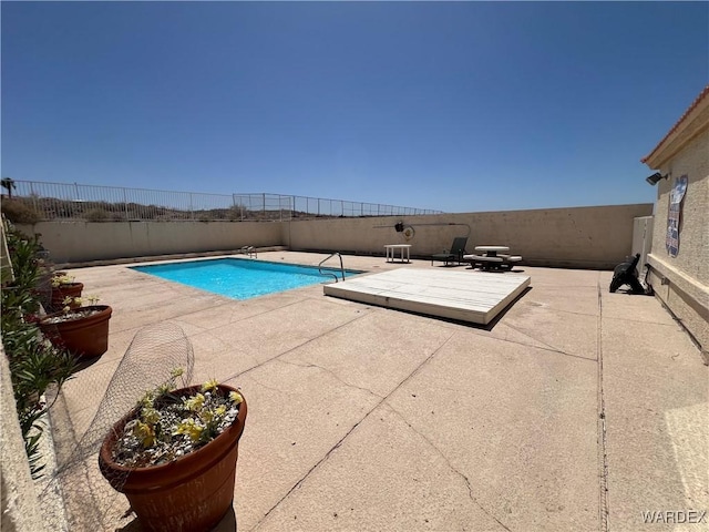 view of swimming pool with a fenced in pool, a fenced backyard, and a patio area