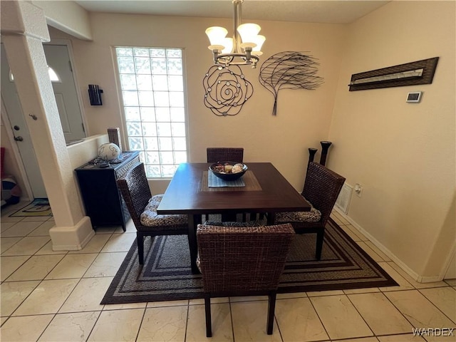 dining area featuring an inviting chandelier and baseboards