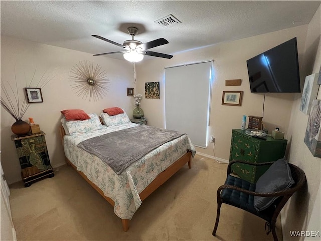 bedroom with light carpet, a textured ceiling, a ceiling fan, baseboards, and visible vents