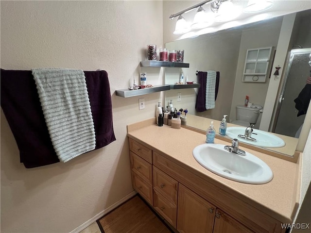 full bathroom featuring vanity, a shower stall, and toilet