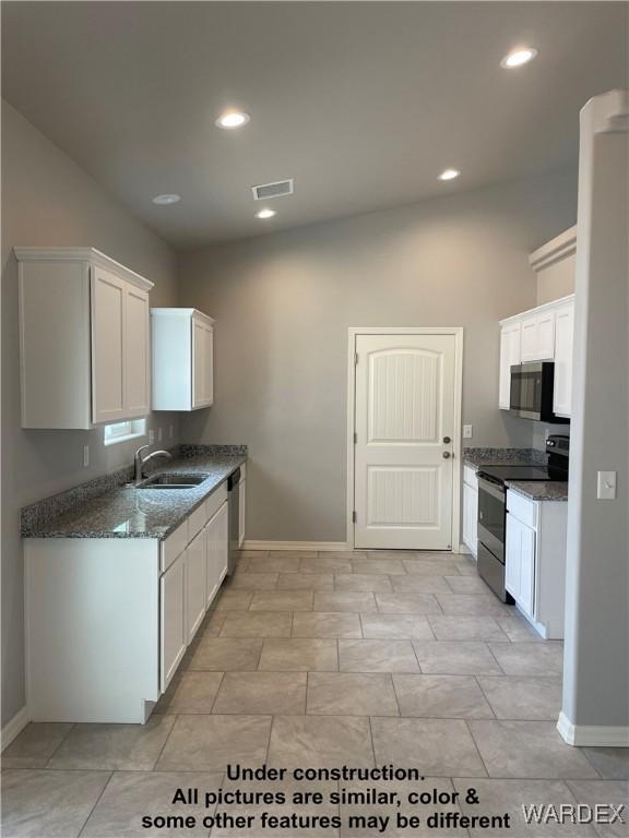 kitchen featuring stainless steel appliances, white cabinetry, a sink, and visible vents