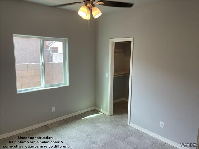 spare room with ceiling fan and baseboards