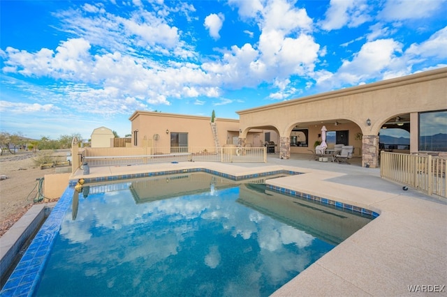 view of swimming pool with a patio area, ceiling fan, fence, and a fenced in pool