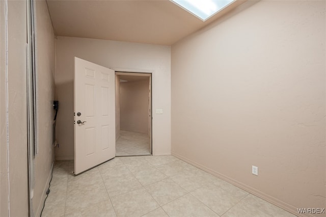 unfurnished bedroom with light tile patterned floors and baseboards