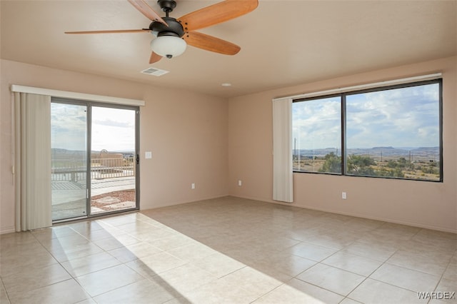 spare room featuring visible vents, baseboards, a ceiling fan, and light tile patterned flooring