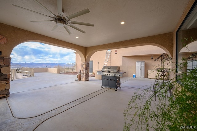 view of patio / terrace featuring a grill, fence, a mountain view, and a ceiling fan