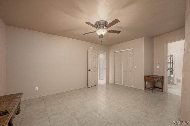 empty room featuring ceiling fan and baseboards