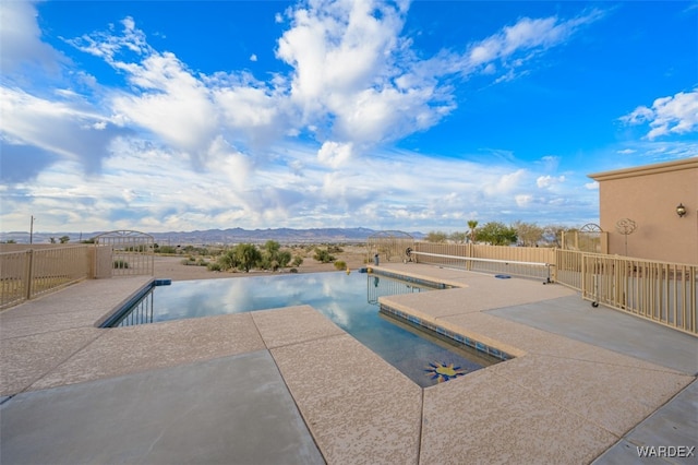 view of pool with a mountain view, a patio, fence, and a fenced in pool