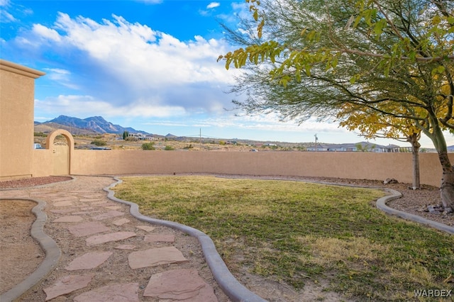 view of yard with a fenced backyard and a mountain view