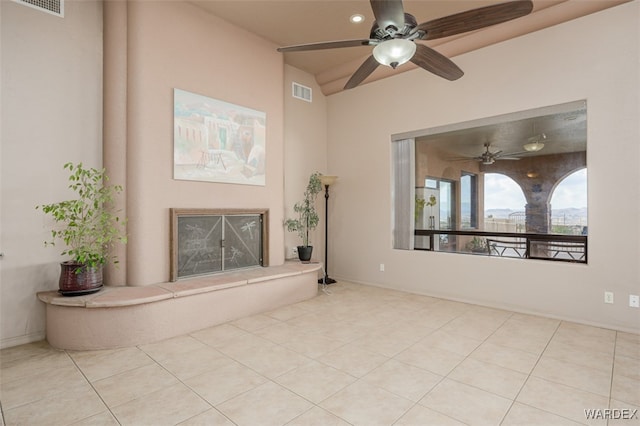 unfurnished living room with light tile patterned floors, visible vents, and a fireplace with raised hearth