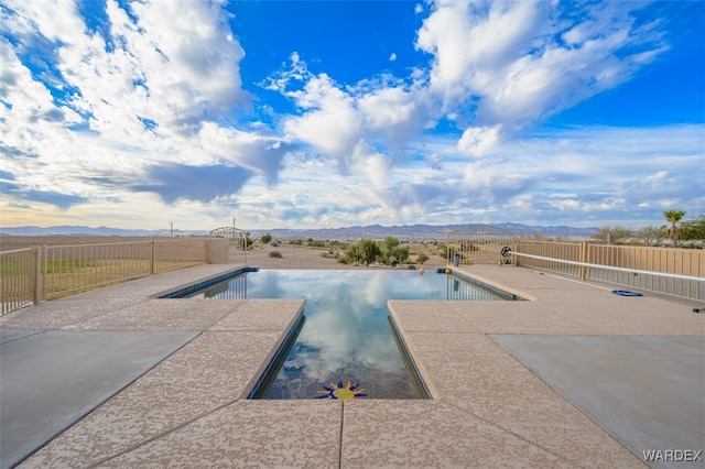 view of pool featuring a fenced in pool, a fenced backyard, a mountain view, and a patio