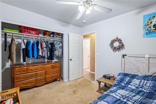 carpeted bedroom with ceiling fan, baseboards, and a closet