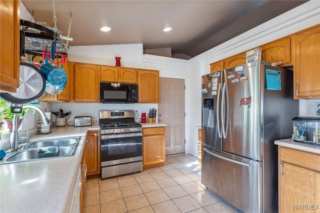 kitchen featuring vaulted ceiling, stainless steel appliances, light countertops, a sink, and light tile patterned flooring