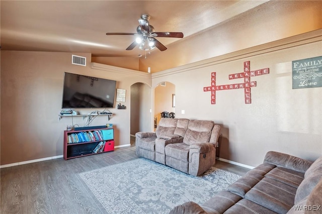 living area with arched walkways, visible vents, ceiling fan, vaulted ceiling, and wood finished floors