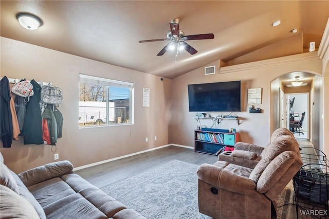 living area featuring arched walkways, lofted ceiling, wood finished floors, visible vents, and a ceiling fan