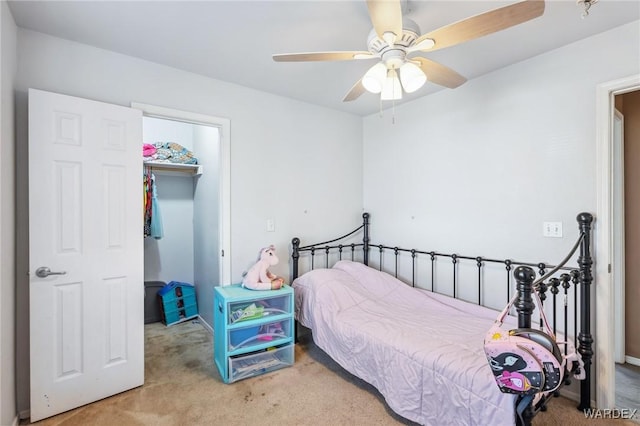 bedroom with carpet floors, a closet, a spacious closet, and a ceiling fan