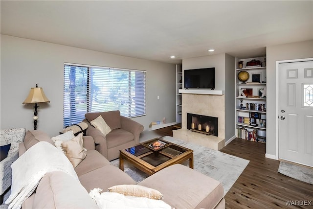 living room with recessed lighting, baseboards, a premium fireplace, and wood finished floors