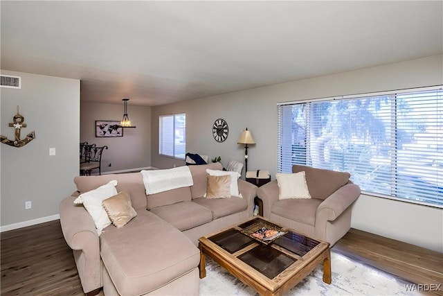 living area featuring wood finished floors, visible vents, and baseboards