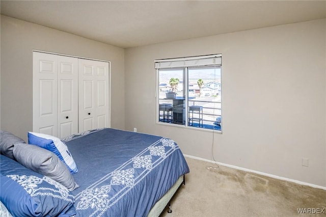 carpeted bedroom featuring a closet and baseboards