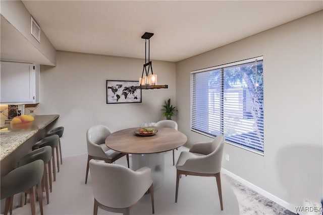 dining area with visible vents, a notable chandelier, and baseboards