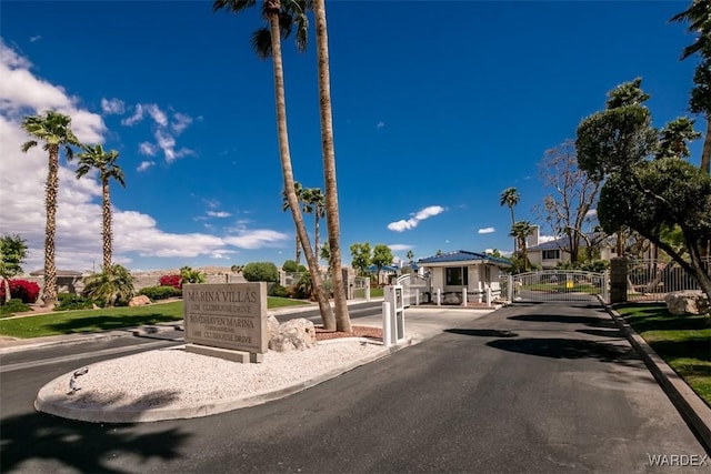 view of street featuring a residential view, a gate, curbs, and a gated entry