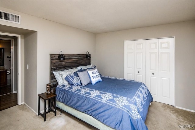 carpeted bedroom featuring a closet, visible vents, and baseboards