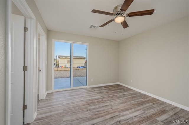 unfurnished room featuring light wood finished floors, baseboards, visible vents, and ceiling fan