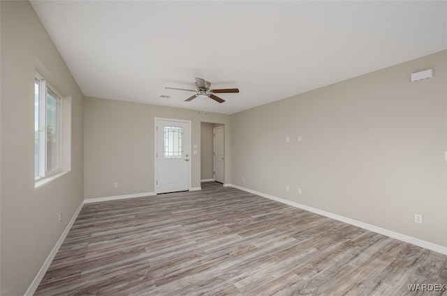 spare room featuring light wood-style flooring, baseboards, and a ceiling fan